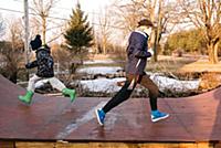 Girl and brother running in opposite directions on