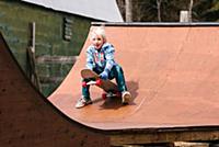 Boy preparing to sit down on skateboard on wooden 