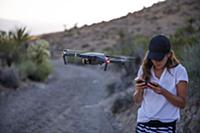 Woman operating drone (unmanned aerial vehicle) on