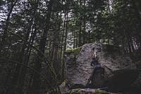 Climber bouldering in forest, Squamish, Canada