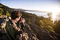 Man taking photographs at sunrise, Lake Tahoe, Tah