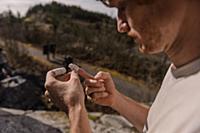 Climber taping fingers before bouldering in forest