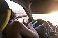 Man driving car shielding eyes from sunlight, over