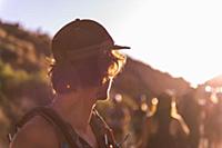 Man in baseball cap looking over his shoulder at g