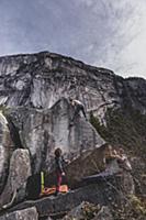 Climber bouldering, watched by friends, Squamish, 
