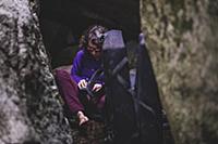 Climber putting on shoes between rocks, Squamish, 
