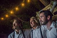Three young men with arms around each other at out
