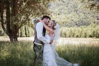 Romantic couple on wedding day kissing in woodland