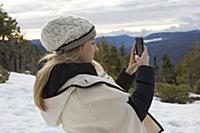 Young woman taking smartphone selfie in winter for