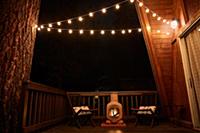 Fireplace and two wicker chairs on verandah of hou