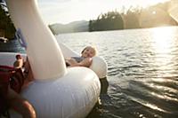 Girls playing on inflatable swan in lake