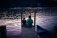 Father and daughter relaxing at lake