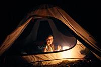 Girl inside tent at night