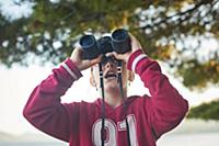 Girl looking up through binoculars