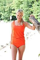 Pretty blonde woman with pigtail in orange swimsui