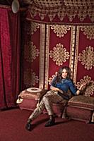 Actress Stephanie Stumph sitting on sofa, looking 