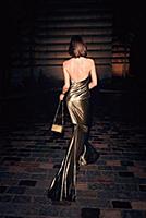 Rear view of woman in golden shiny backless dress 