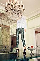 Woman wearing sequin pants standing on a table and