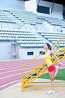 Side view of woman wearing sportswear stretching h