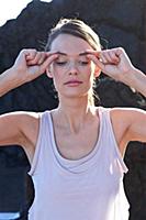 Brunette woman performing sukshma yoga exercise on