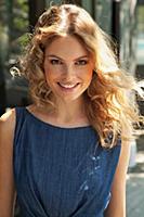 A young blonde woman outside wearing a blue summer