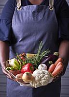 Woman holding a basket with fresh ingredients