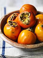 Kaki fruit in a ceramic bowl