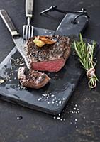 Grilled steak with garlic and a bundle of rosemary