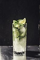 Cucumber gin with tonic in a kirstall glass agains