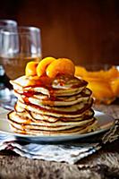 Stack of homemade pancakes with poached peaches