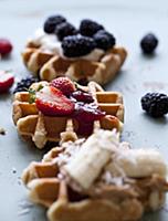 Waffles topped with strawberry jam and strawberrie