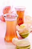 Bottles of homemade rose water with limes and peta