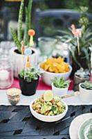 Guacamole and potted succulents on table set for M