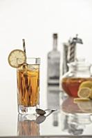 Vodka ice tea with lemon garnish and striped straw