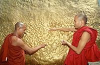 MYANMAR / Mon State / Monks donating gold leaf on 