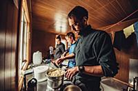 man cooking in a cabin, greenland, arctic.