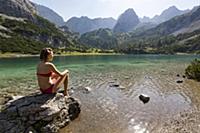 Girl in bikini sitting at Lake Seebensee with Drac