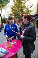 Женщина-промоутер предлагает парфюмерию на улице.