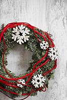 Wreath decorated with wooden snowflakes and red co